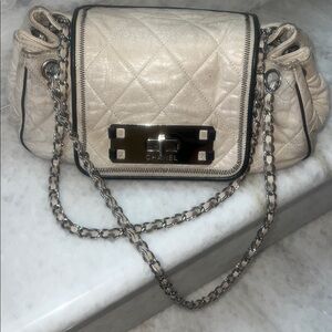 Authentic CHANEL Beige Quilted handbag with black piping.